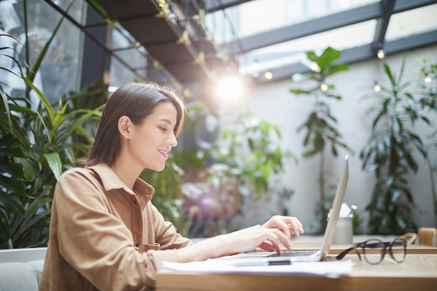 Female Entrepreneur Using Laptop in Outdoor Cafe