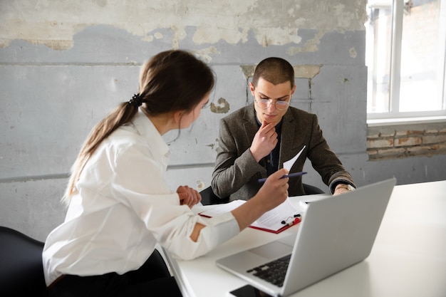 Female estate agent showing new home to a young man after a discussion on house plans moving new home concept