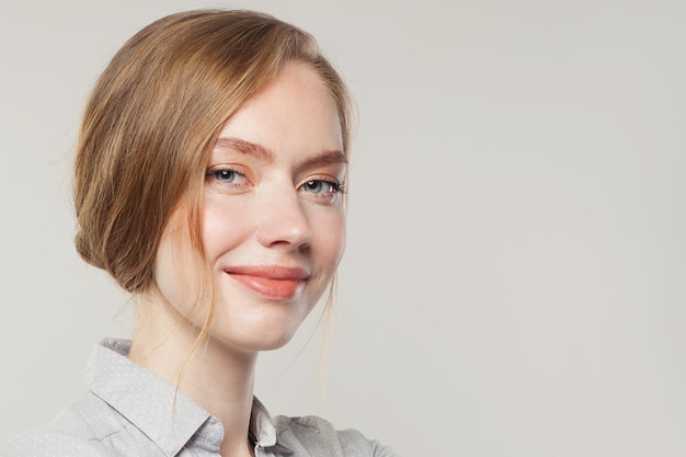 Female face close up on white Young woman smiling