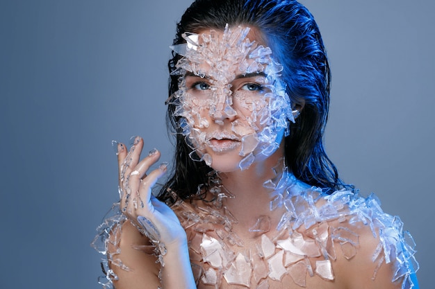 Female face covered with a lot small pieces of glass