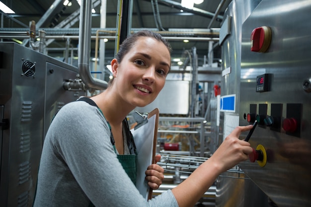 Female factory worker operating machine