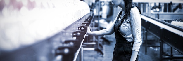 Female factory worker standing near production line