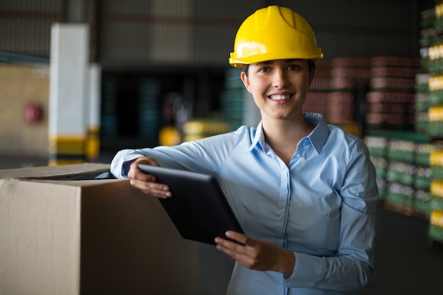 Female factory worker standing with digital tablet in factory