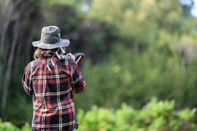 Female farmer in a field walking away from camera Girl studying a soil and plant sample in field scientist in a paddock