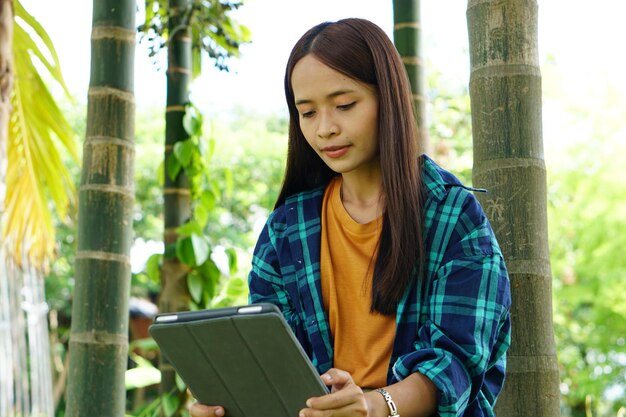 Female farmer is happy after viewing results from a laptop computer Increased profits