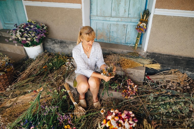 Female farmer makes bouquets of dried flowers grown in the garden