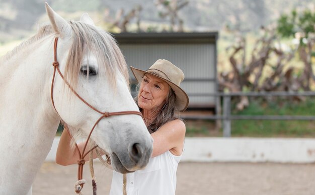 Photo female farmer with her horse at the ranch