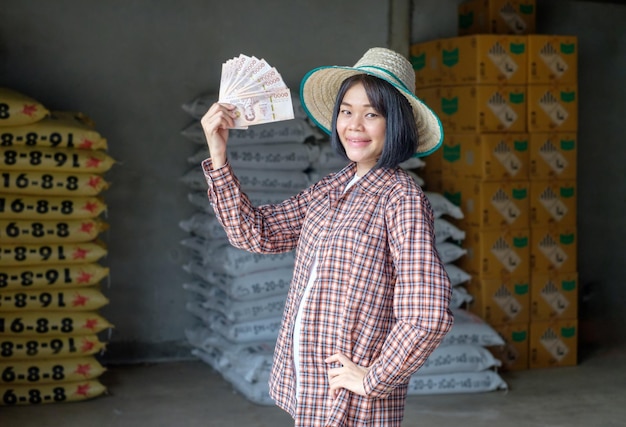 Female farmers pose with banknotes to promote their products