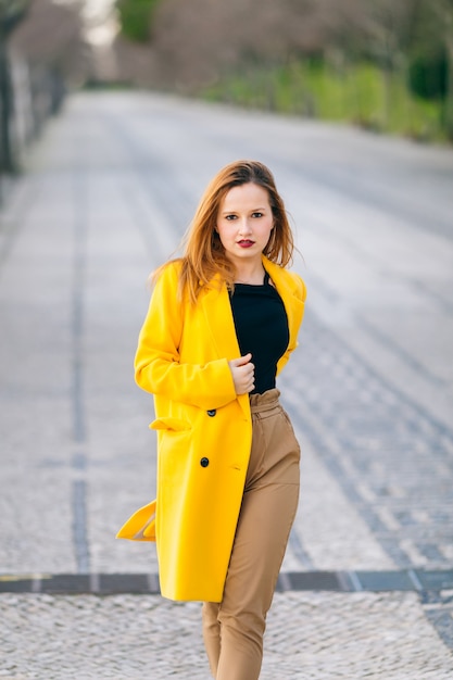 Female fashion concept. girl in a yellow coat with a beautiful m