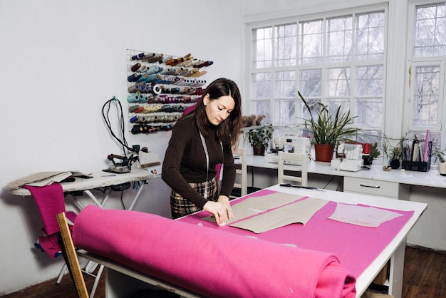 Female fashion designer tailor making sewing patterns at\
workplace in sewing studio