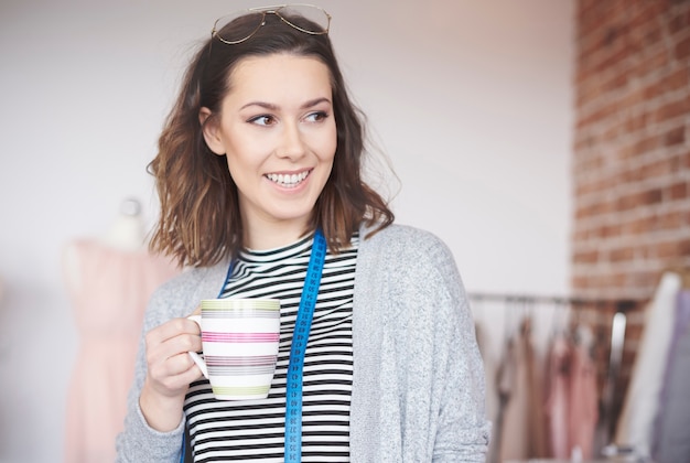 Stilista di moda femminile con una tazza di caffè