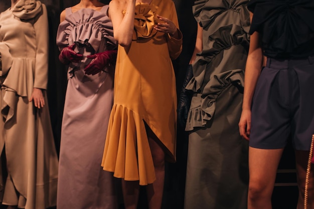 Female fashion figures in stylish creative outfits on backstage area before the show