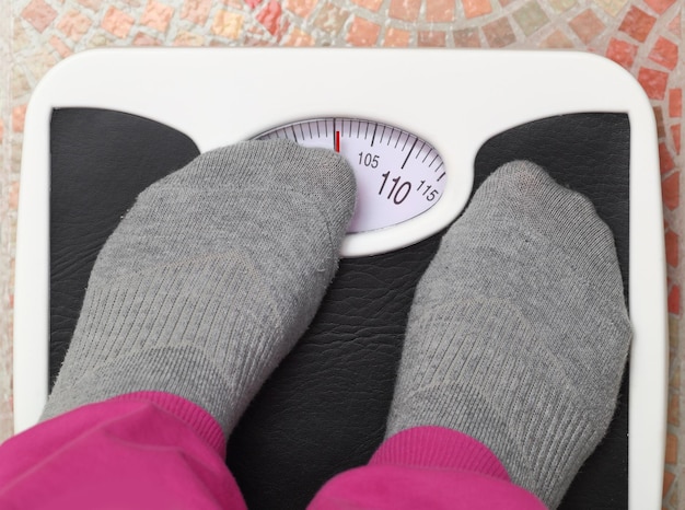 Photo female feet on bathroom scale