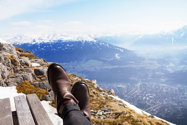 Female feet on edge of wooden bench. 