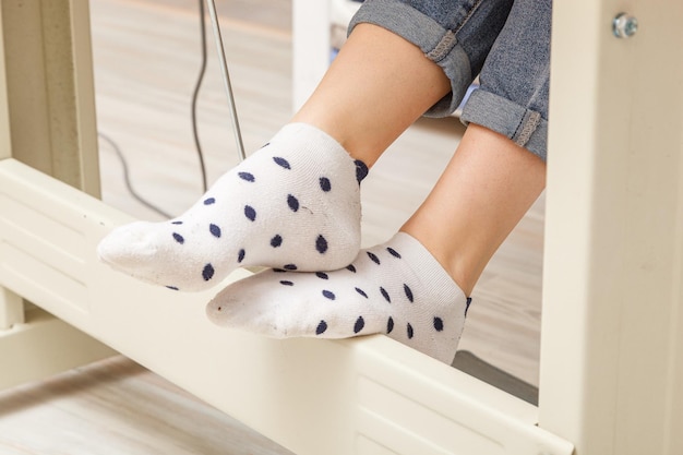 Female feet on the pedal of a sewing machine motor