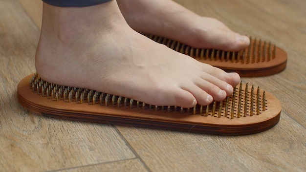 Female feet standing on boards with nails close up media barefoot female standing on yoga nails