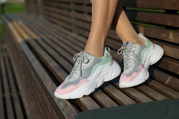 female feet wearing sport sneakers outdoors