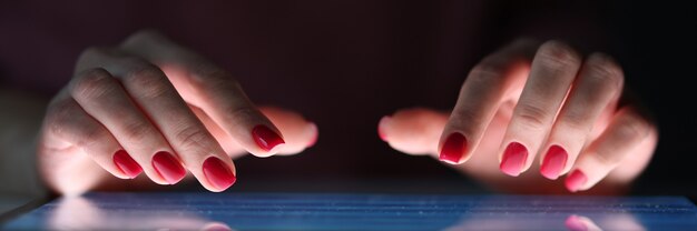 Female fingers on tablet screen at night irregular working day concept