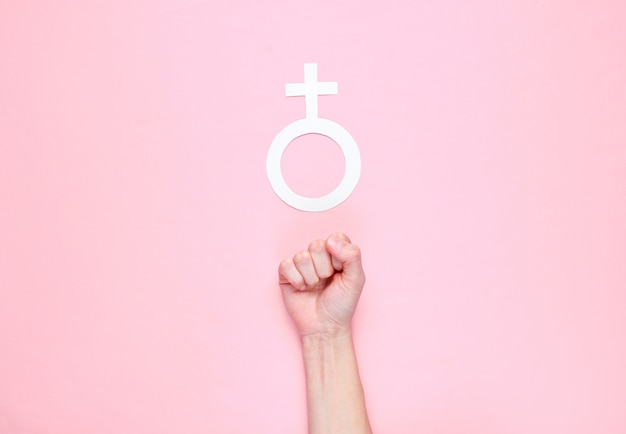 Photo female fist, gender female sign on a pink background