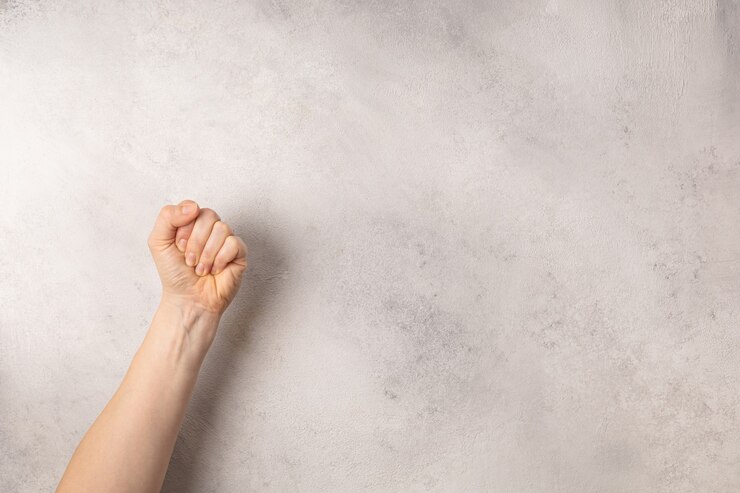灰色の背景に女性の拳