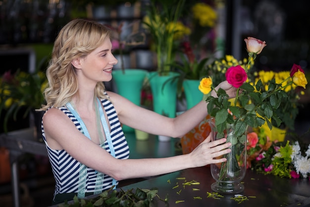 花瓶に花の花束をアレンジする女性の花屋