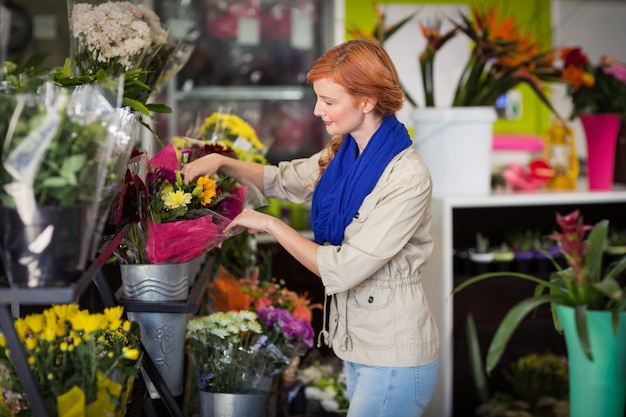 Fiorista femminile che organizza il mazzo del fiore