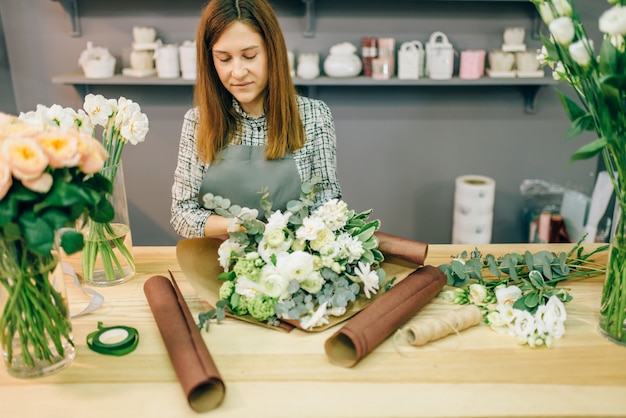 Female florist decorate fresh flower composition