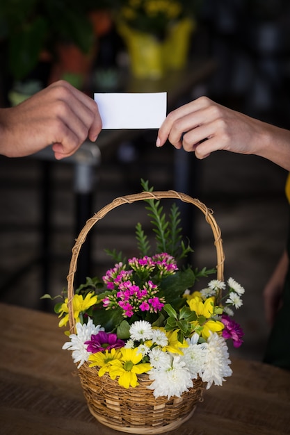 Female florist giving visiting card to customer