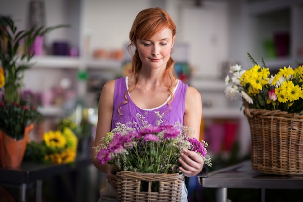 Женский флорист держит корзину с цветами