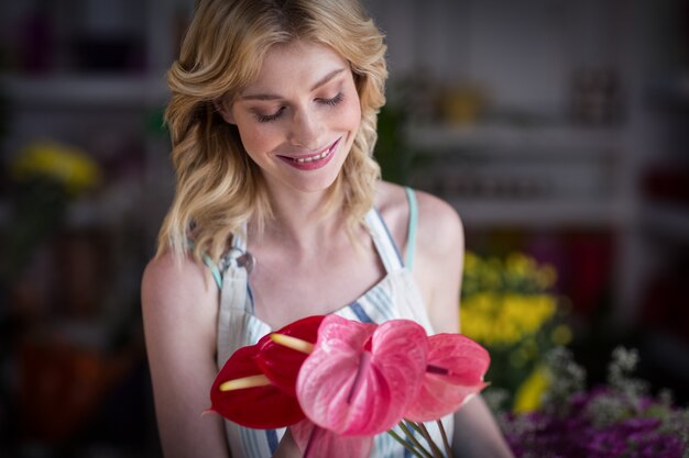 Female florist holding flowers in flower shop