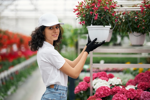 Female florist holding pot with blooming flower