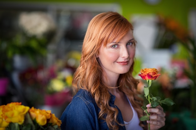 バラの花を保持している女性の花屋