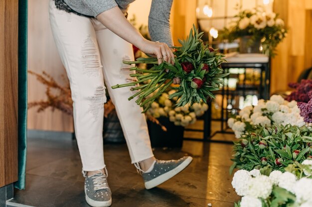 Женский флорист делает букет в цветочном магазине