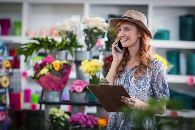 Female florist taking order on mobile phone