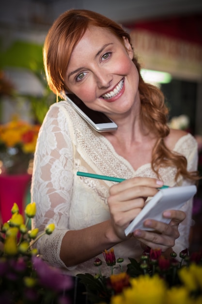 Female florist taking order on mobile phone