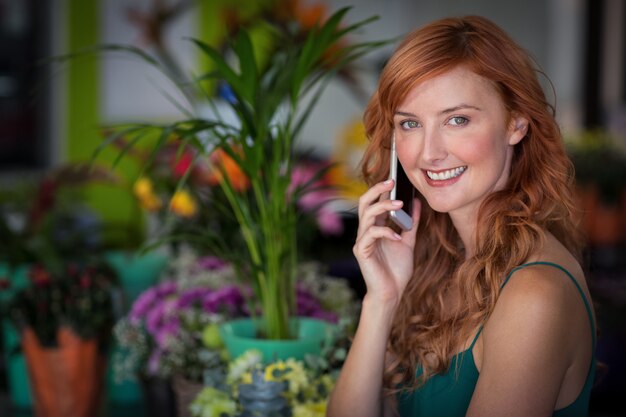 Female florist talking on mobile phone in flower shop