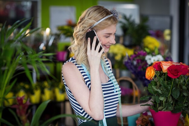 휴대 전화 통화하는 여성 꽃집