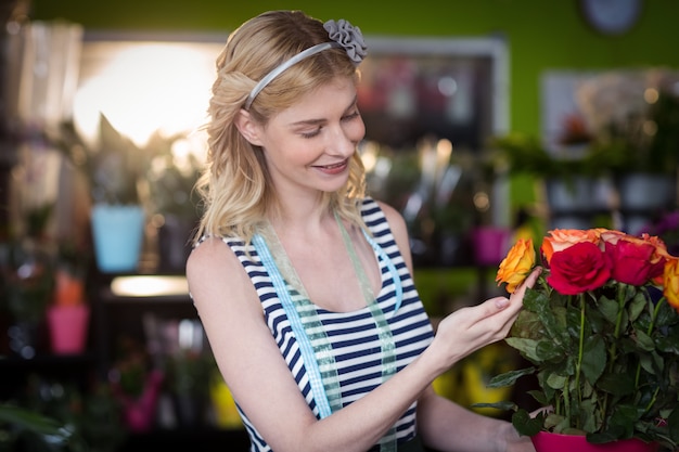 Female florist touching rose flowers