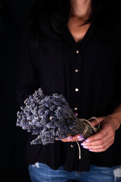 Female florist tying up fresh bouquet with lavender