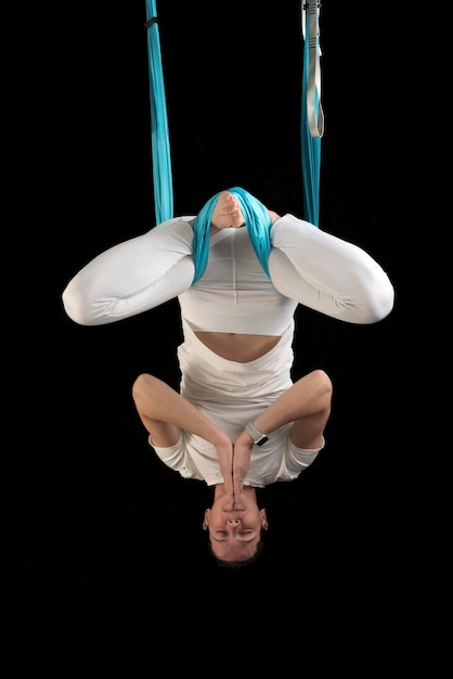 Photo female fly yoga instructor hangs on hammock in the lotus position upside down aerial antigravity yoga
