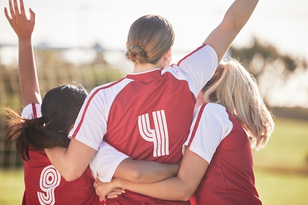 Photo female football team celebrating winning goal or teamwork effort at a game tournament or during practice on a field outdoors behind of women with arms raised in celebration victory and joy