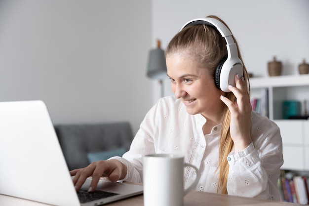 Female freelancer listening a podcast on headphones while working