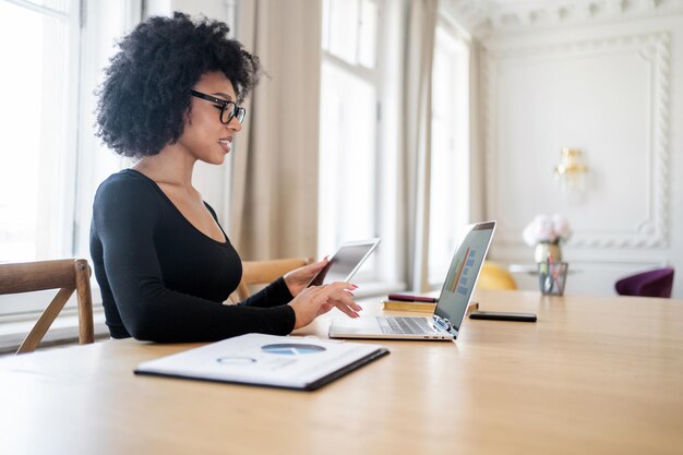 Female freelancer manager works in office workspace uses laptop\
formal wear coworking space