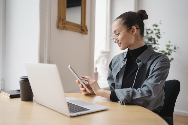 A female freelancer works with glasses uses a laptop writes a reply message to the client by mail Company Report