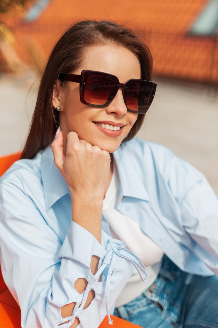 Photo female fresh street portrait of a beautiful happy young woman with a sweet smile in fashion casual clothes sitting outdoors on a sunny warm spring day