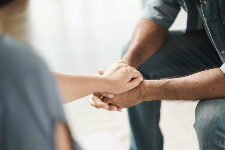 Photo female friend or family sitting and hold hands during cheer up to mental depress man, psychologist provides mental aid to patient. ptsd mental health concept