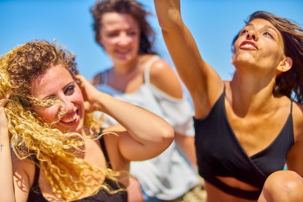 Female friends against clear blue sky