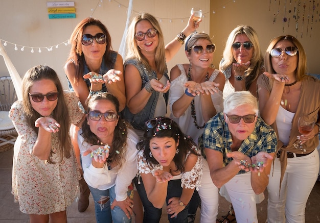 Foto amiche che soffiano i confetti durante la festa