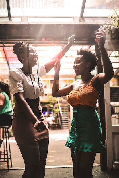 Female friends dancing in cafe