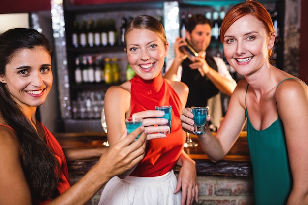 Female friends enjoying tequila in night club